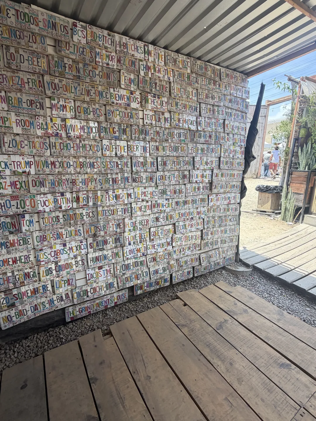 A wall covered with hand-painted license-plate signs inside the artisan market